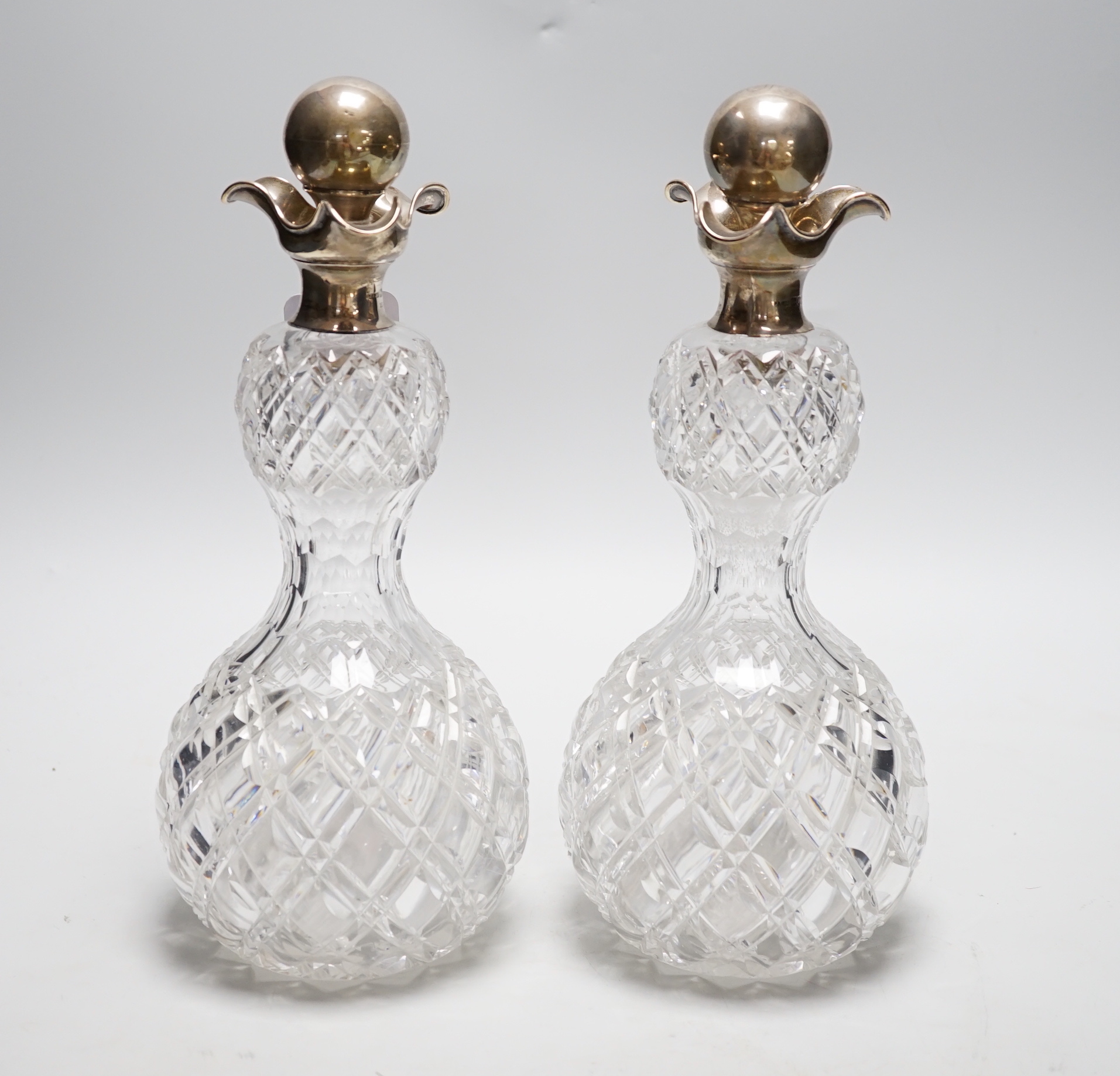 A pair of late Victorian silver mounted cut glass waisted tri-lipped decanters, with stoppers, John Grinsell & Sons, London, 1900, 28.5cm.